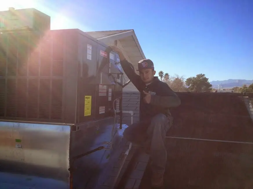 HVAC technician performing AC Tune-Up on a rooftop unit in Dowagiac